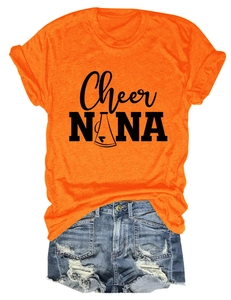 Flat lay detail of bright orange crew neck t-shirt with Cheer NANA print and denim shorts