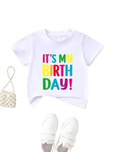 Flat lay of white cotton birthday tee with accessories and white sneakers