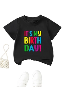 Detail of black cotton kids birthday t-shirt with colorful printed lettering and accessories