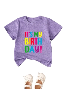 Flat lay of purple heather birthday t-shirt with white bow lace baby shoes