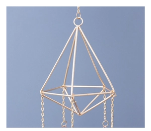Detail of golden geometric suncatcher prism with metallic chains and octahedron frame