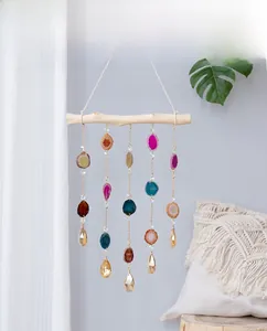 Detail view of five natural agate slices and crystal prisms on a wooden wall hanging