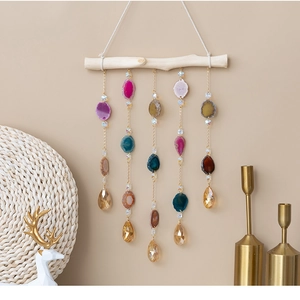 Detail of bohemian wall hanging with natural agate slices and teardrop crystal pendants