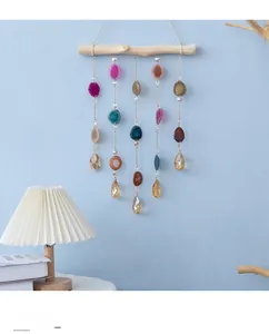 Detail view of boho agate wind chime with natural wood bar and colorful sliced stones