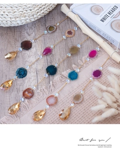 Detailed close-up of colorful agate slice suncatchers with crystal drops on gold chains