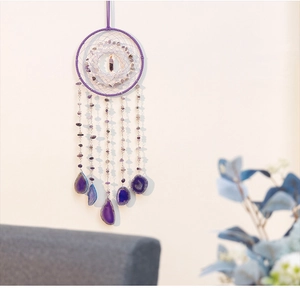 Detail view of purple dream catcher with amethyst stones and natural agate slices