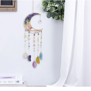 Detailed close-up of a crescent moon dreamcatcher with colorful raw crystal stones