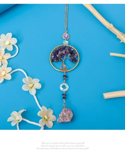 Détail d'un pendentif de voiture arbre de vie avec améthystes et fil doré tressé