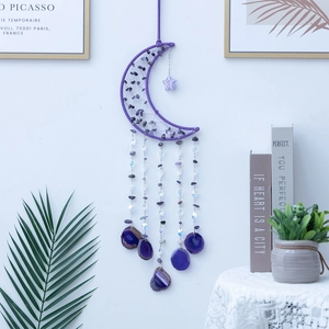 Amethyst crescent moon crystal wind chime with purple agate slices hanging on a white wall
