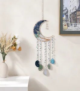 Detail of moon-shaped dreamcatcher wall hanging with natural agate slices and crystal stones