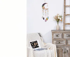 Detail of moon dreamcatcher with healing crystals and agate slices on white wall