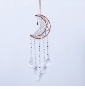 Detalle de atrapasueños en forma de luna con tejido artesanal y colgantes de piedra