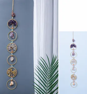 Detail of amethyst tree of life suncatcher with raw crystal stones and golden rings