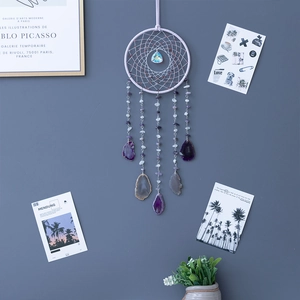 Capteur de rêves bohème avec quartz fraise et tranches d'agate sur mur gris