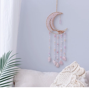 Detail of moon-shaped pink crystal dreamcatcher with gold wire and stone tassels