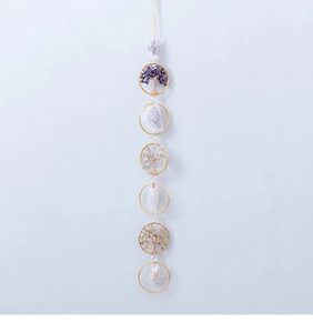 Vertical detail of handmade life tree hanging with natural crystals and golden rings