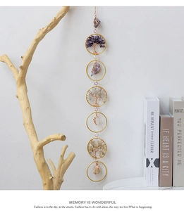Detail of tree of life suncatcher with natural crystal stones and golden wire weaving