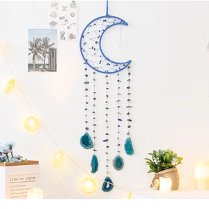 Detailed close-up of blue moon dream catcher with agate slices hanging on white wall