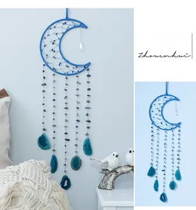 Macro detail of agate moon dreamcatcher with blue stones and handmade woven feathers