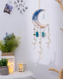 Dettaglio dell'acchiappasogni a luna con cristalli, fette di agata blu e cornice dorata