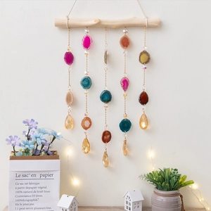 Handmade agate slice wind chime with crystal droplets hanging on a natural wooden beam