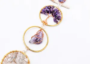 Detail of handmade suncatcher with purple crystal tree of life and raw amethyst stones
