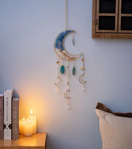 Dettaglio di ciondolo a luna in cristallo con pietre blu e fetta di agata per decor