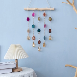 Bohemian agate wind chime with crystal droplets hanging from a natural wood branch