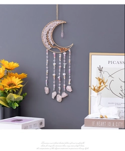 Close-up of pink crystal dreamcatcher with tree of life wire art on crescent moon frame
