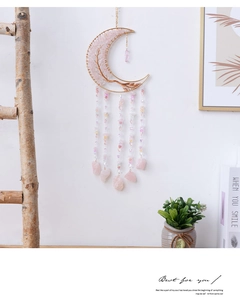 Detail of moon-shaped dream catcher featuring pink crystal tree and hanging raw stones