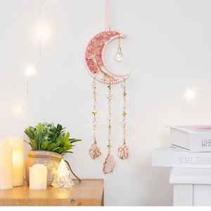 Close-up of pink crystal moon dreamcatcher with life tree pattern and hanging stones