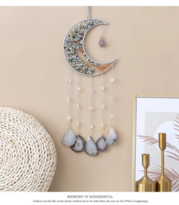 Detail of moon-shaped wall hanging with tree of life design and agate stone slices
