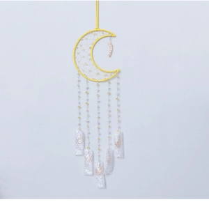 Detailed macro view of yellow moon-shaped dreamcatcher with beads and crystals decoration