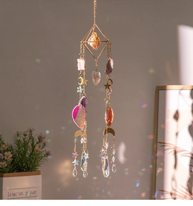 Detail of crystal suncatcher with natural aventurine stones creating rainbow prism light