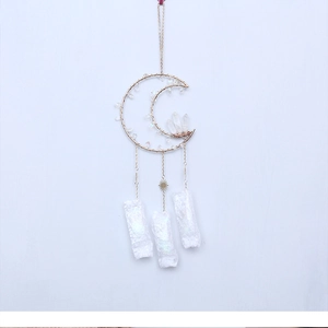 Detail of golden moon suncatcher with raw crystal pendants and intricate wire wrapping