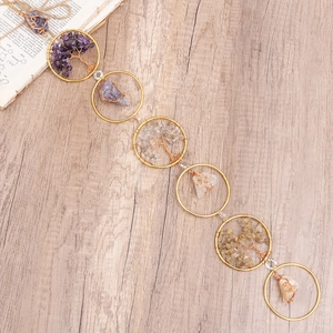 Handmade Tree of Life crystal suncatcher with natural stones on a wood background