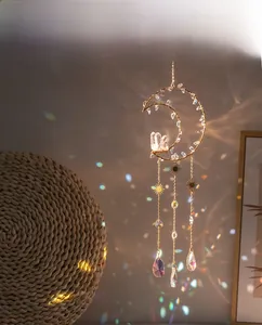 Detail of bohemian moon suncatcher with crystals casting rainbow light on a soft background