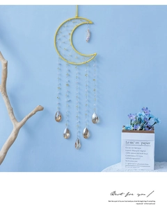 Detail of yellow moon wind chime with woven mesh and crystal teardrop pendants
