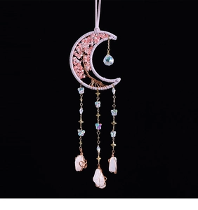 Detailed view of handmade pink moon dream catcher with tree of life stones and feathers