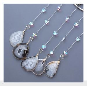 Detailed view of natural agate slices with silver chains and butterfly beads wall hanging