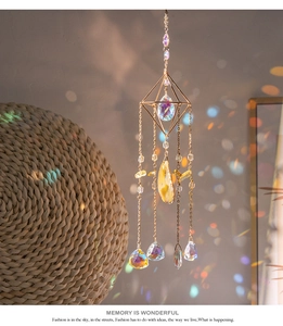 Detalle de atrapasol de cristal con marco dorado y cristales tallados creando arcoíris