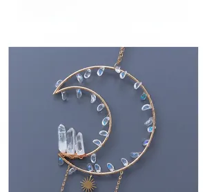 Detail of moon sun crystal suncatcher with golden frame and natural white crystal cluster