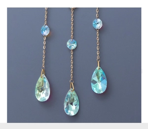 Detail of crystal suncatcher with gold chains and teardrop iridescent pendants