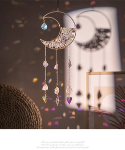 Detail of golden moon suncatcher with purple crystals and rainbow heart prism pendant