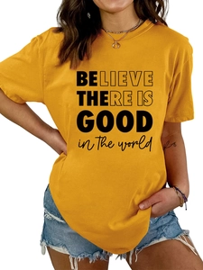 Détail d'un t-shirt jaune à col rond avec le message Believe There Is Good