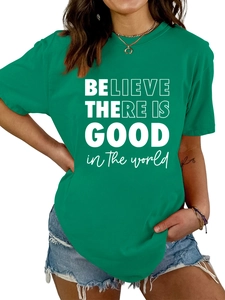 Détail du t-shirt vert en coton avec lettrage blanc BELIEVE THERE IS GOOD imprimé