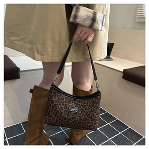 Detail showing leopard print tote bag with black leather straps on trench coat model