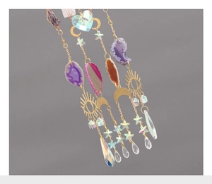 Detail of sun catcher with agate slices, golden celestial charms, and faceted crystals