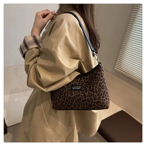 Close-up of leopard print crossbody bag styled with a khaki trench coat for an urban retro look