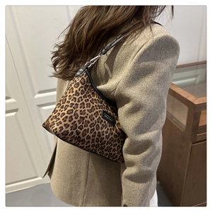 Dettaglio della borsa tote leopardata con etichetta tessuta nera e fibbia in metallo argento